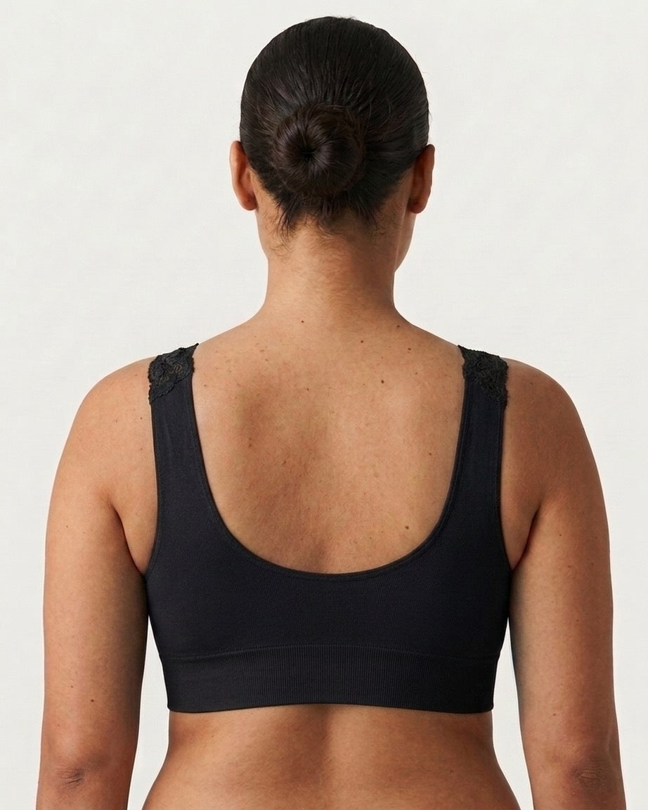 Rear view of a woman wearing a black Seamless UW Bra w/ Lace Sling, set against a plain light gray background.