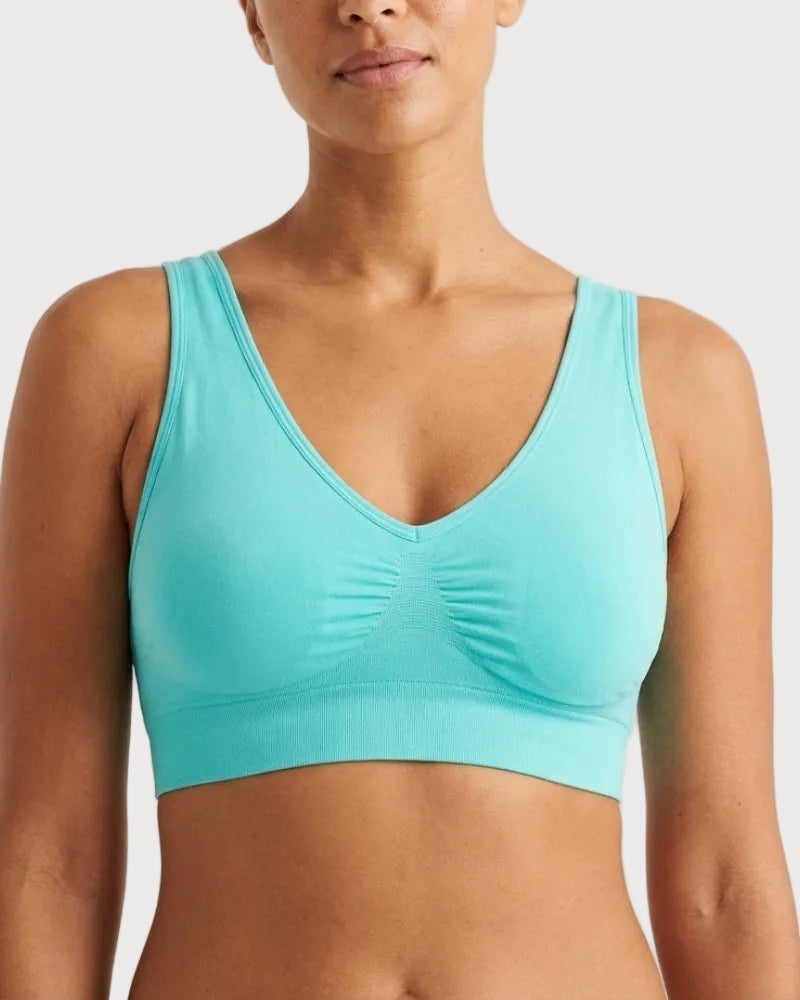 A woman wearing a light aqua Original Ahh Bra® against a light gray studio background.