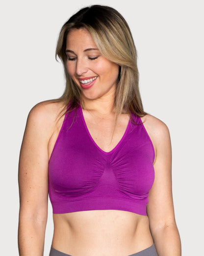 A woman wearing a bright purple Seamless Racerback Ahh Bra, shown against a plain light gray background.